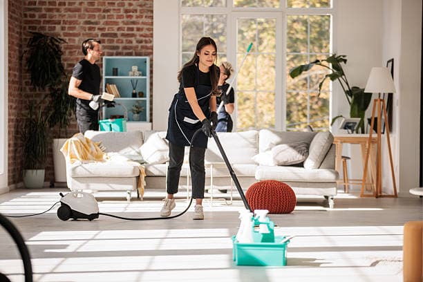 House cleaner wiping a kitchen counter in morning daylight